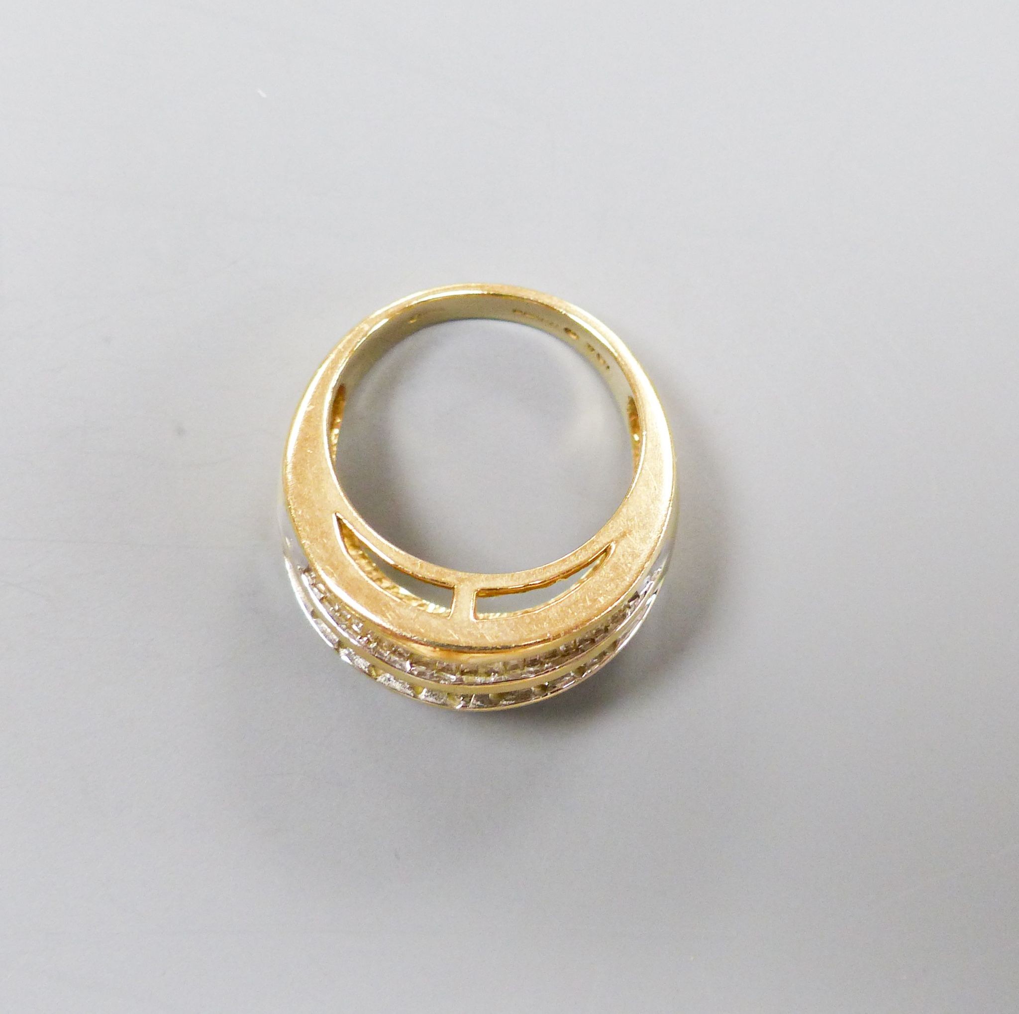 A modern 9ct gold and four row round and baguette cut diamond set dress ring, size N/O, gross 7.2 grams.